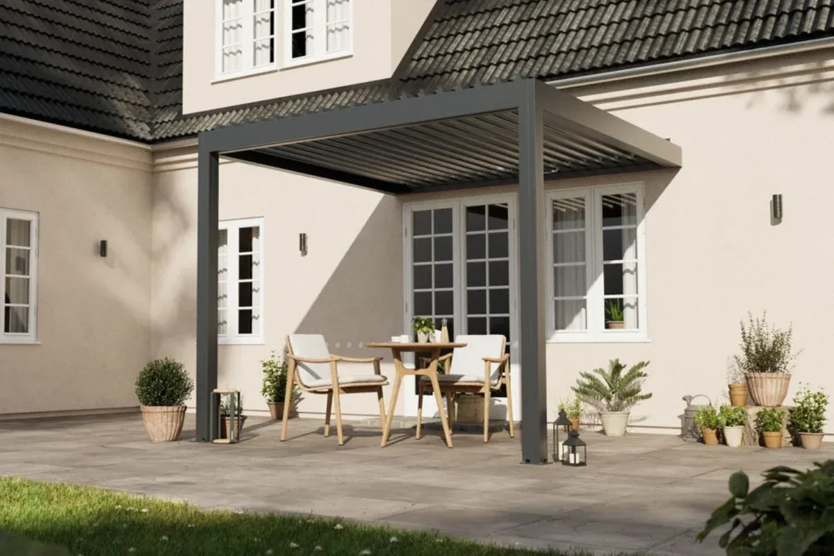 Moderni terasa prie šviesaus namo fasado su minimalistine pergola ir stilingais mediniais lauko baldais.