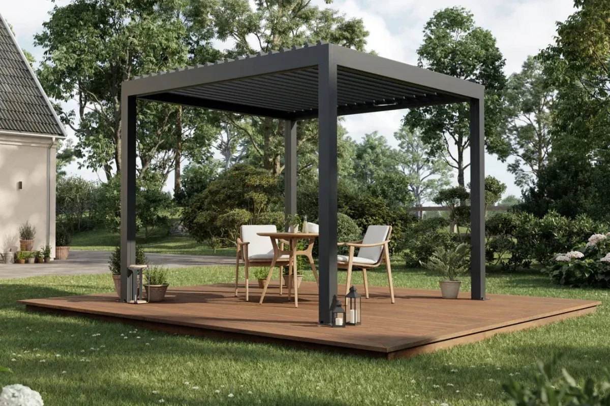 Moderni skandinaviško stiliaus pergola su tamsiu rėmu, stovinti medinėje terasoje sode, apsupta žalumos.