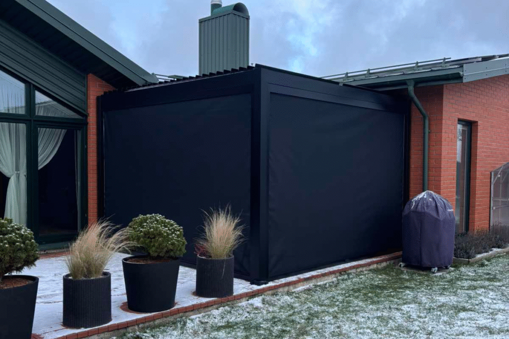 Ta pati pergola žiemos metu su nuleistomis šoninėmis užuolaidomis, apsaugančiomis nuo oro sąlygų.